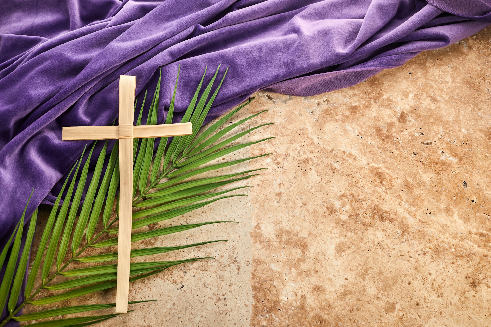 Lent season, Holy week and Good friday concept. Palm leave and cross on stone background