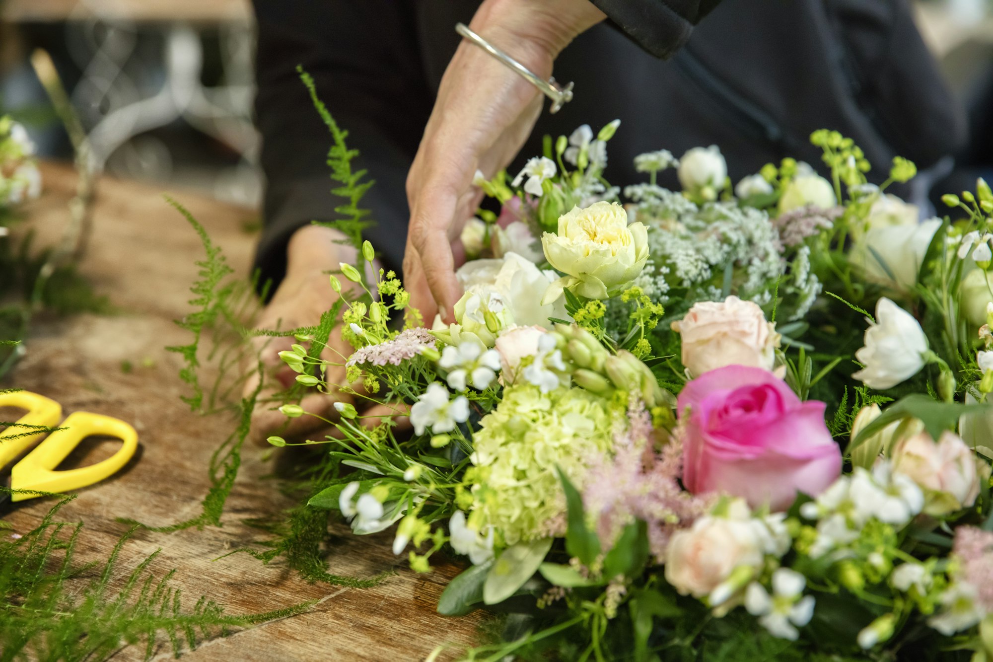A woman working on a flower arrangement, a trained florist.