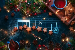 Christmas melody notes flat lay with star-shaped cookies, fir tree branches, wooden tray, anise